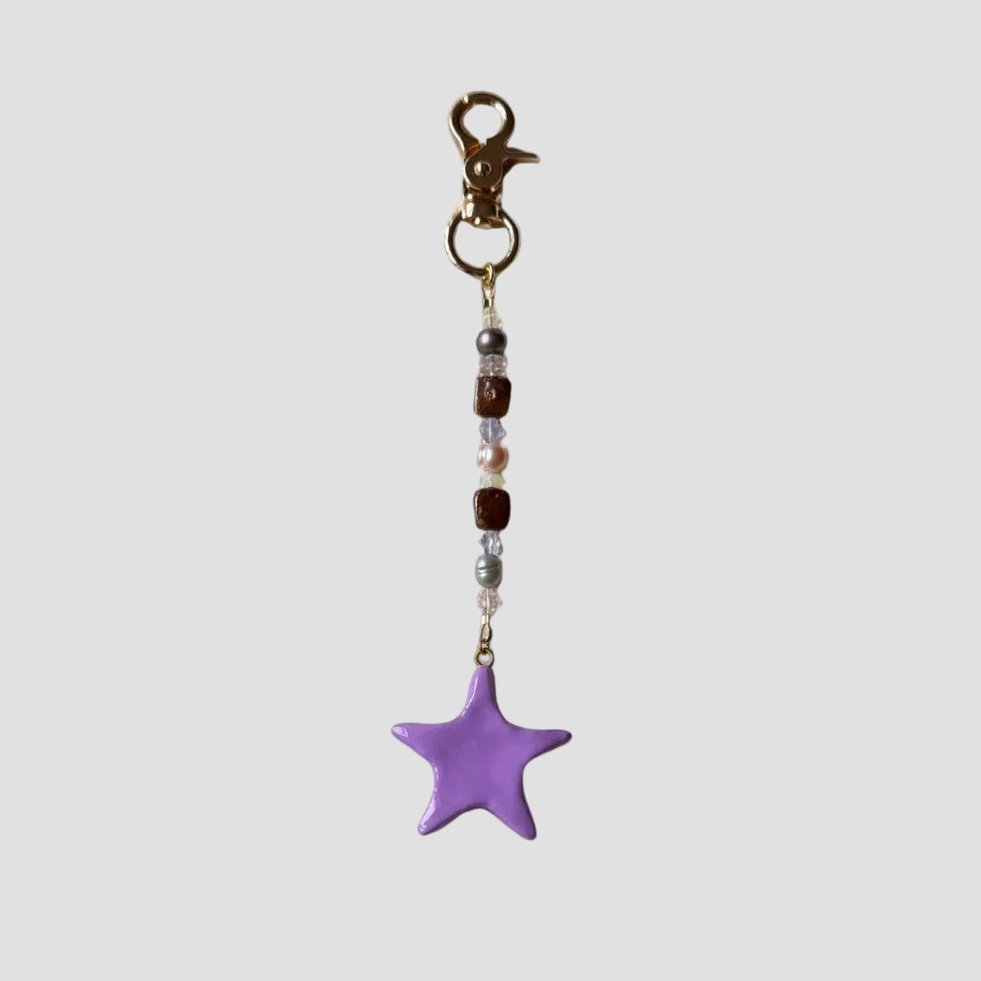 Keychain with a purple star charm on a white background
