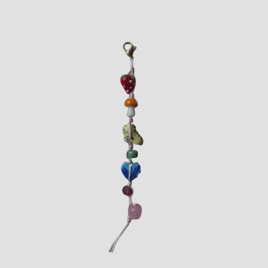 Colorful beaded keychain with heart, rainbow, and other shapes on a white background