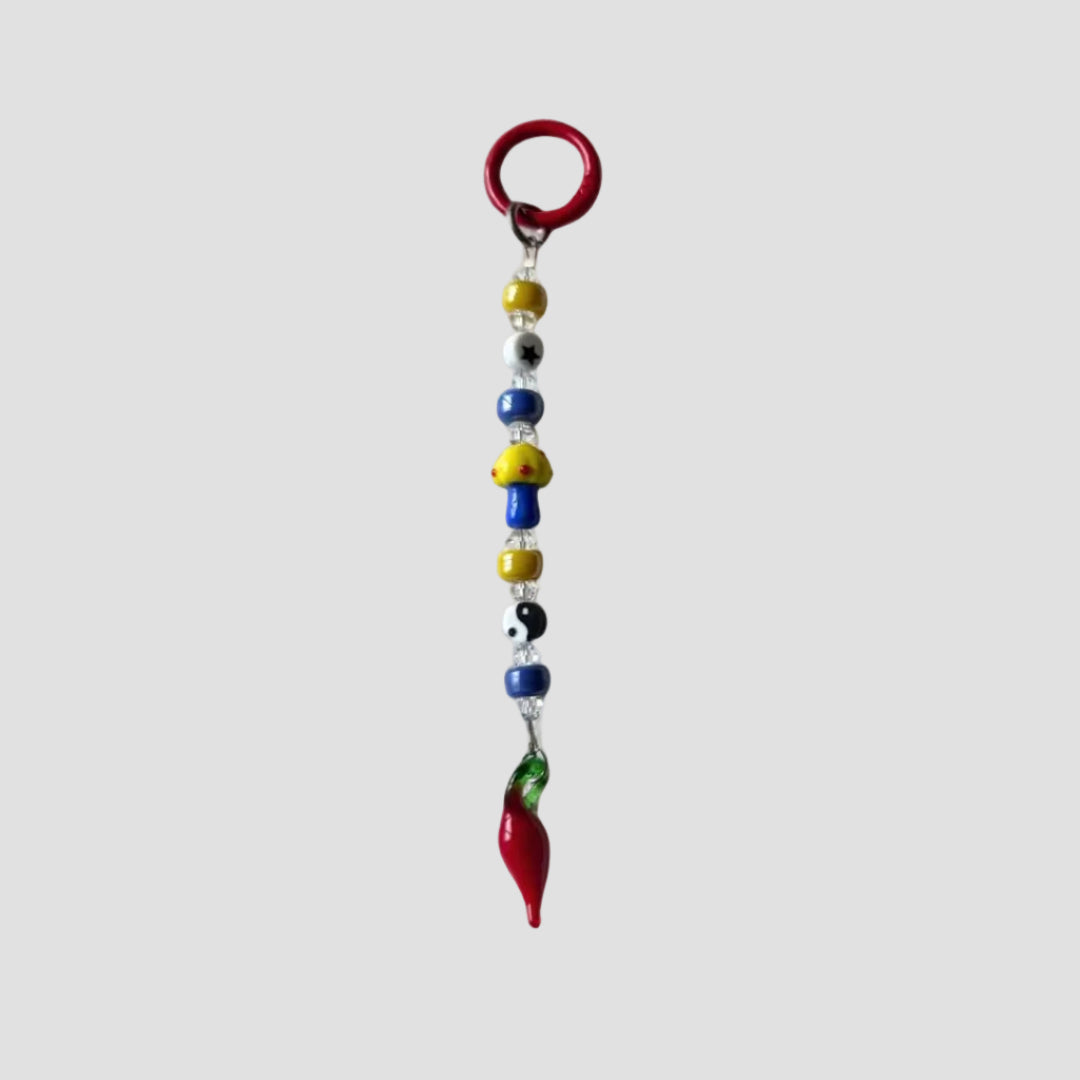 Colorful beaded keychain with a red chili pepper charm on a white background