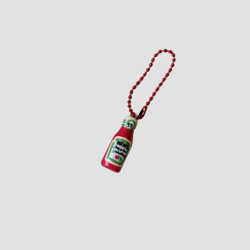 Keychains shaped like ketchup bottles on a white background