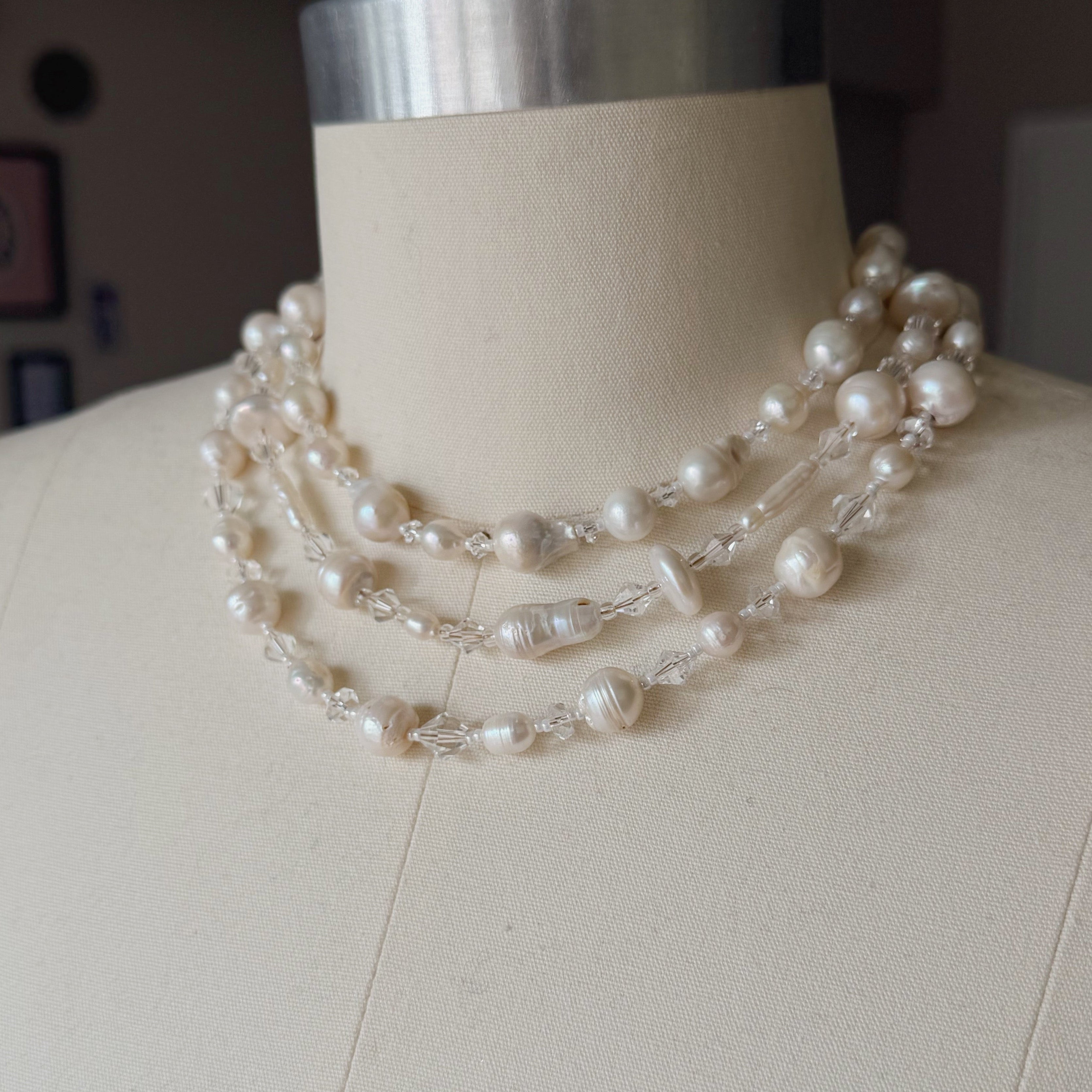 Pearl necklace on a mannequin with a neutral background