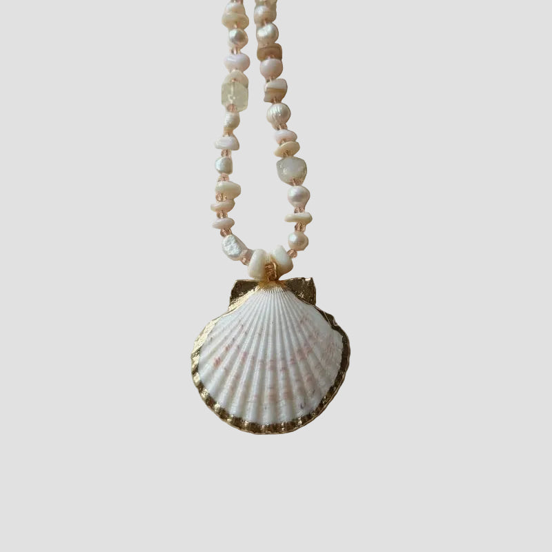 Necklace with shell pendant on a light fabric background