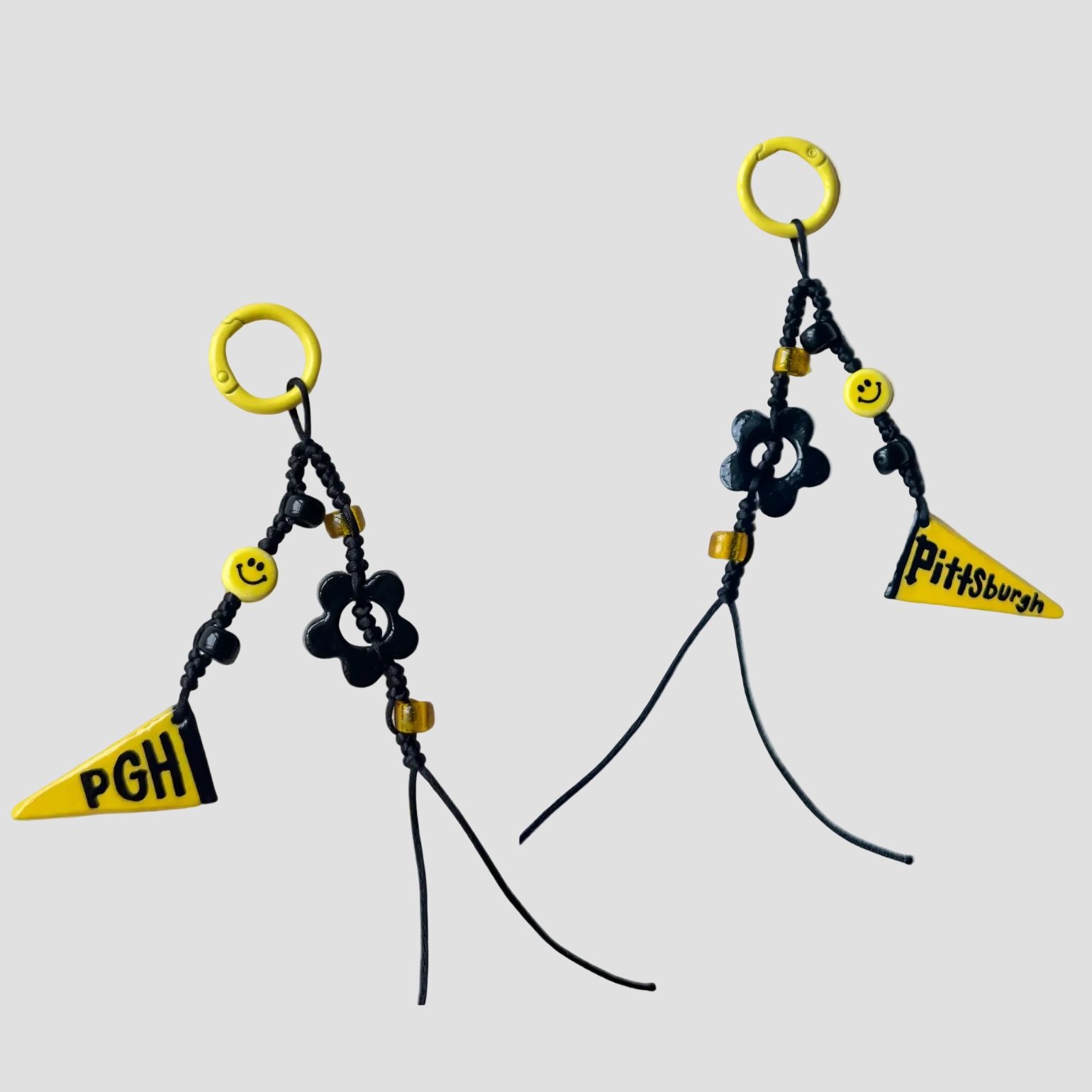Black and yellow bag charm with 'Pittsburgh' and 'PGH' text on a white background
